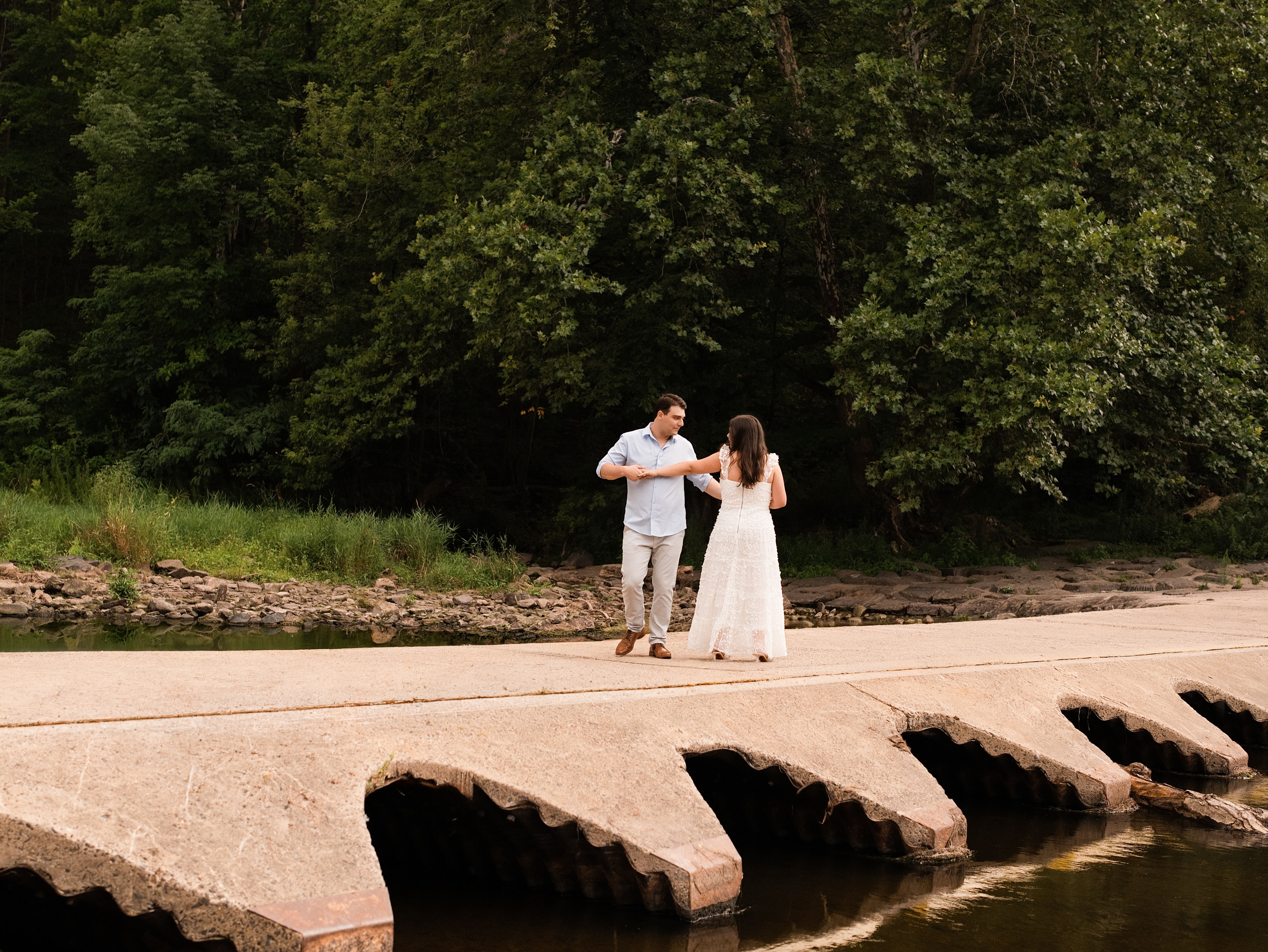 Carolina and Jason dancing together beside the water