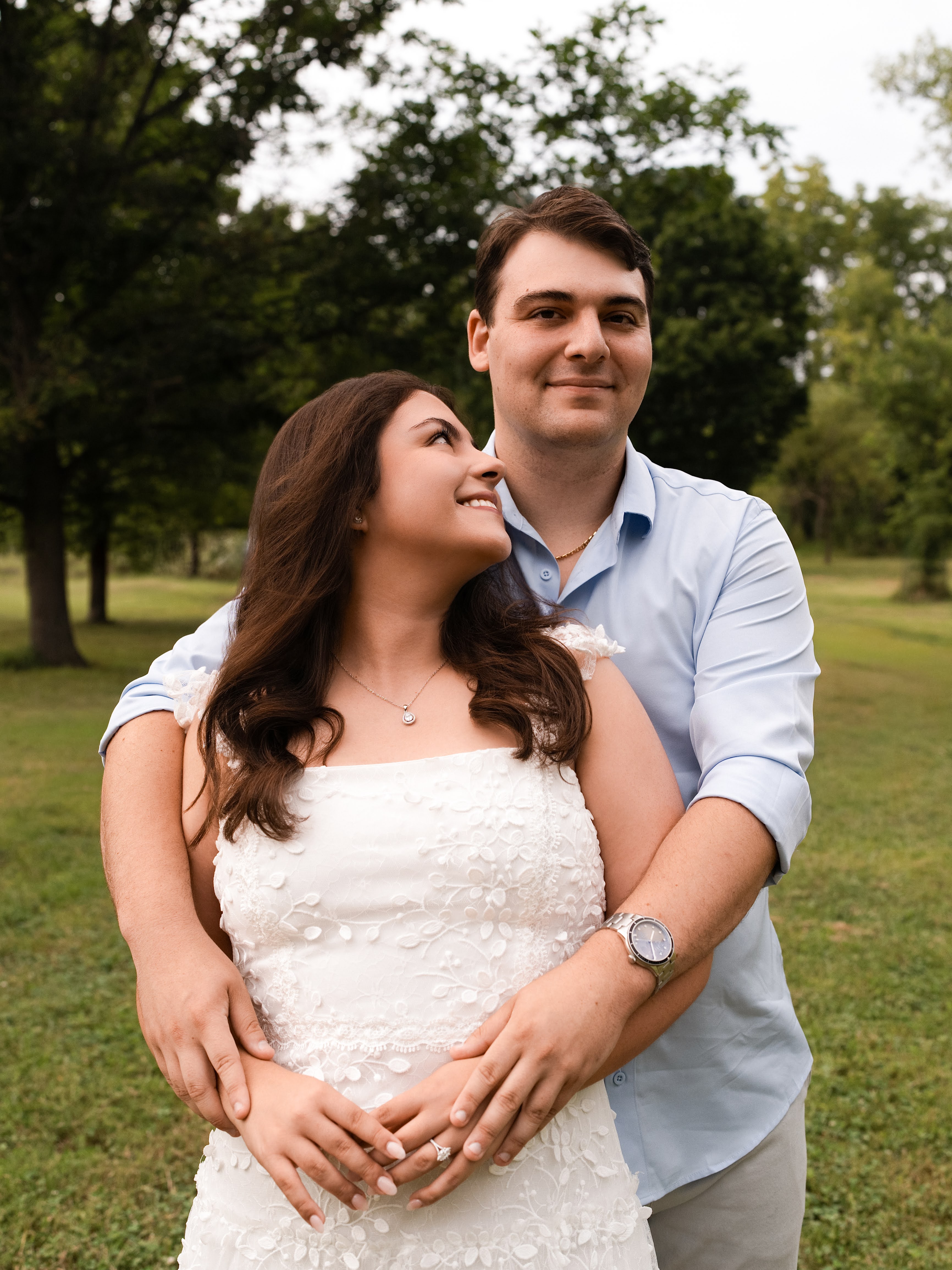 Carolina smiling up at Jason as they embrace outdoors