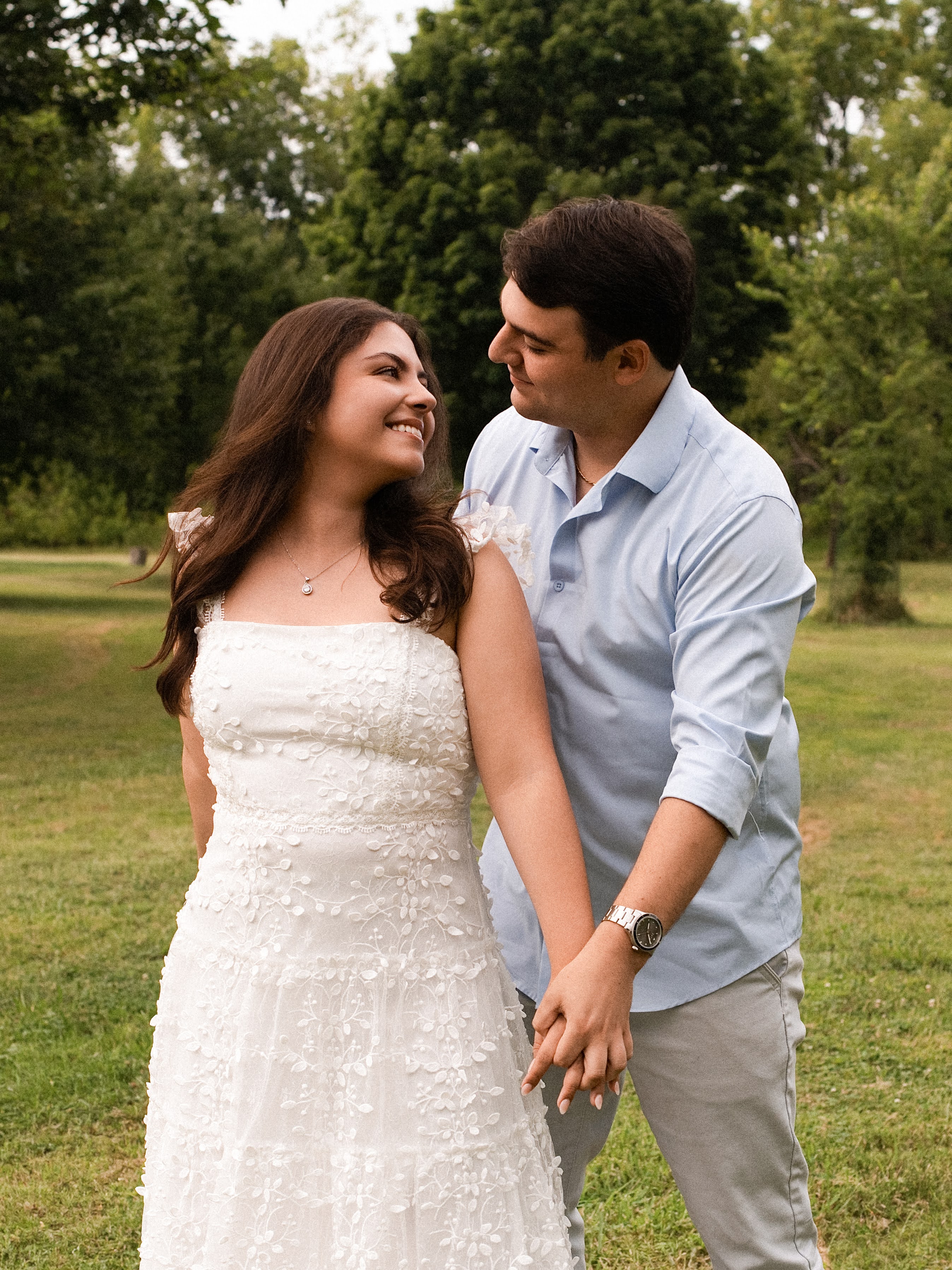 Carolina and Jason smiling at each other in a field